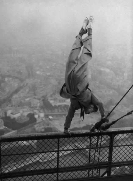 A man performing a handstand on a fence with grace and balance.