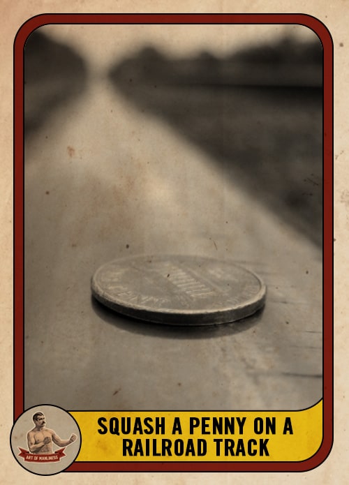 Black & white penny on a railroad track.