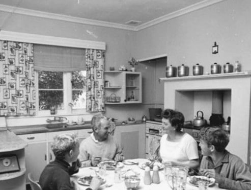 Vintage family at dinner table in home.
