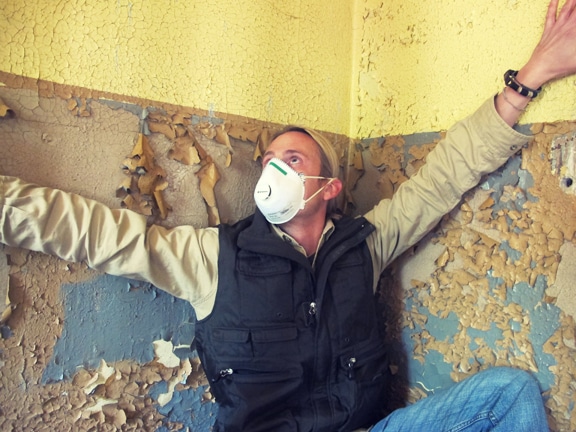 Man wearing face mask at disaster house.