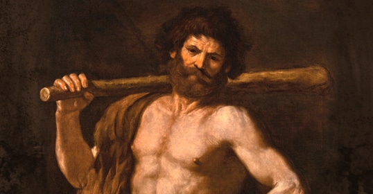 A muscular, bearded man with curly hair stands holding a large wooden club over his shoulder, draped in a brown cloak against a dark background—embodying Hercules at the Crossroads, ready to choose the hard path toward the good life.