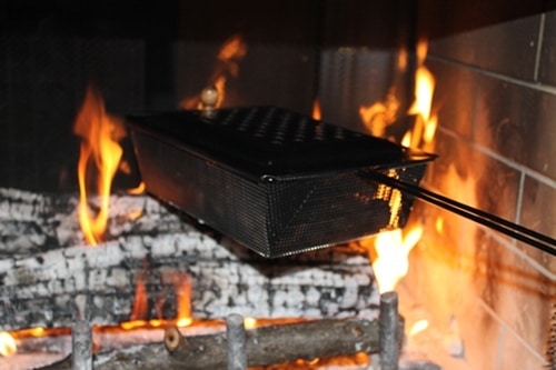 Roasting chestnuts in the pan on fireplace.