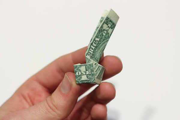 Curled dollar bill with "1" facing front.