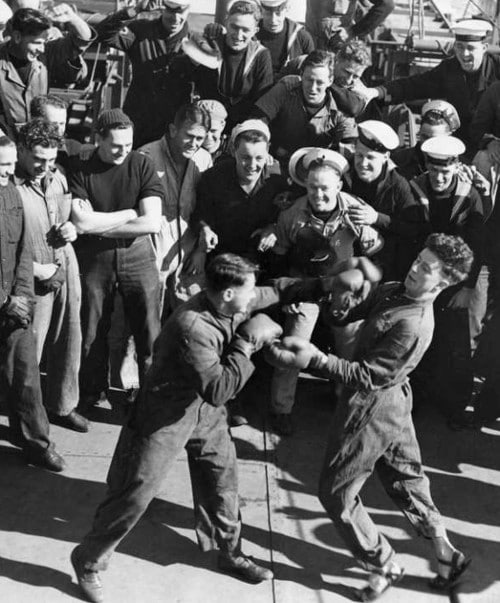 Vintage men boxing in public area. 
