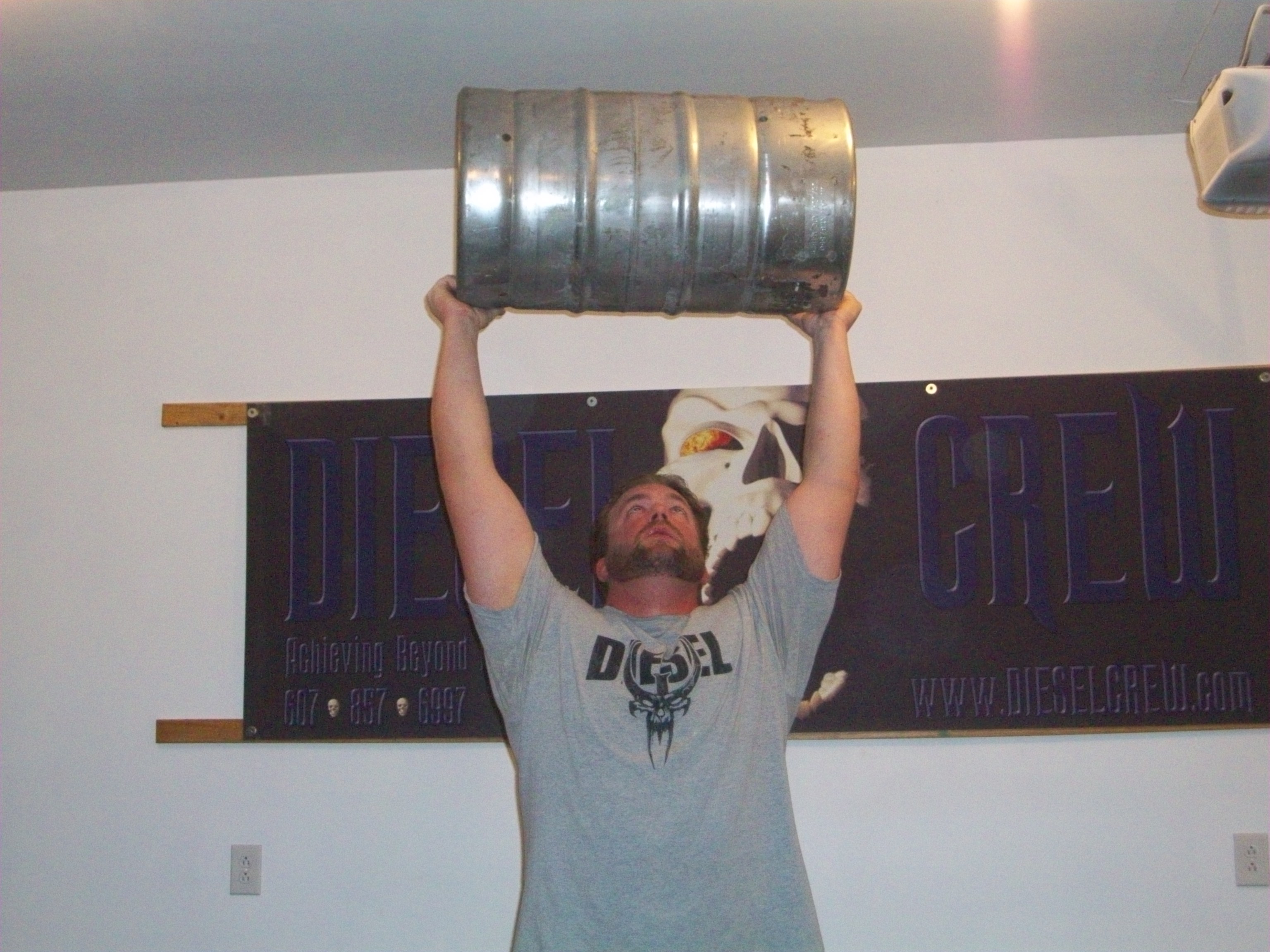 Man lifting an overside keg. 