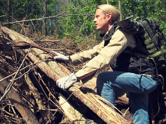 Man going for hiking wearing leather gloves and backpack.