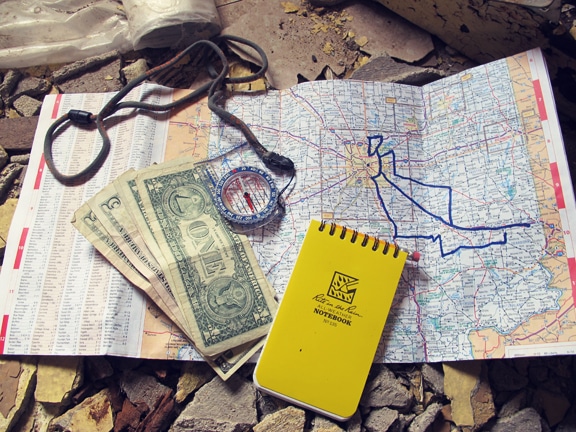 Money and notebook placed on map.