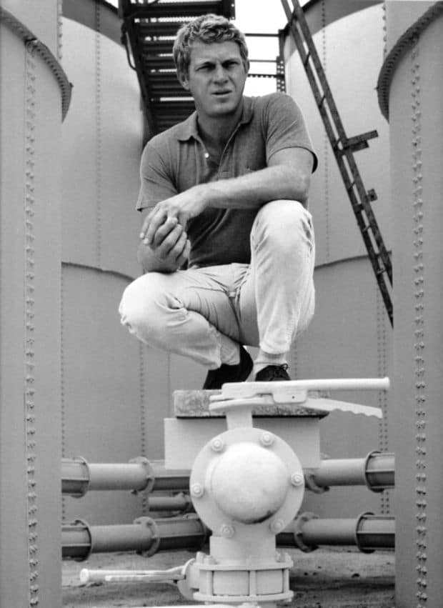 Steve mcqueen sitting on navy ship. 