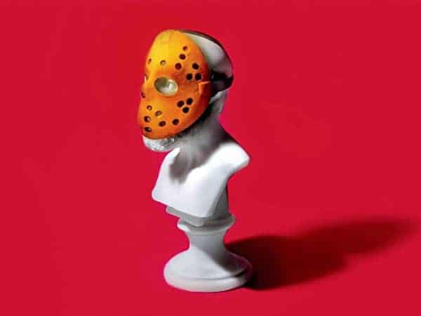 A bust statue wearing a hockey mask against a red background, embodying the wisdom discussed in Podcast #889.