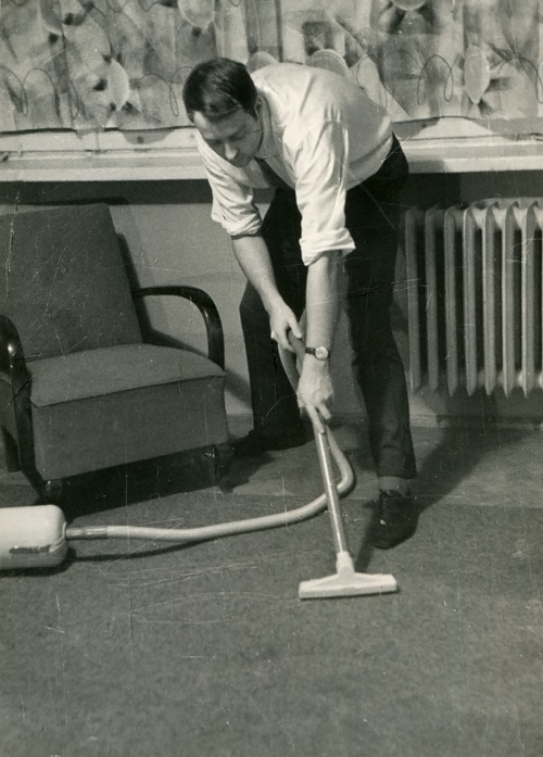 shutterstock_70410385(1) Vintage man vacuuming floor business clothes.